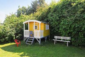 ベンサージールにあるFerienhaeuser Friesensterneの小さな黄色の家(ベンチと椅子付)