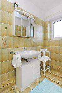 ein Bad mit einem Waschbecken und einem Spiegel in der Unterkunft Ferienwohnung Deichklause in Bensersiel