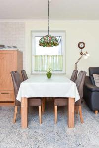 uma sala de jantar com uma mesa branca e cadeiras em Haus Benser Riff em Bensersiel
