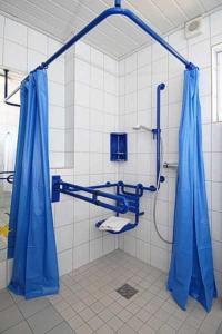 ベンサージールにあるFerienwohnungen Haus Wattkiekerのバスルーム(青いカーテン、シャワー付)