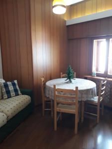 una sala da pranzo con tavolo, sedie e divano di Villa Aremogna a Roccaraso