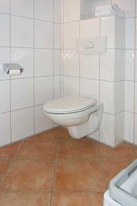 ein Badezimmer mit einem weißen WC und einem Waschbecken in der Unterkunft Nordseegartenpark Nordseestolz in Bensersiel