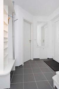 a bathroom with white walls and a tiled floor at Nordseegartenpark Nordseestolz in Bensersiel