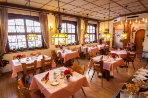a restaurant with tables and chairs with pink tablecloths at Hotel Garni Lehrertal in Ulm