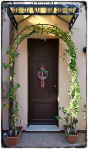 a front door of a house with an arch with plants at Bed&Breakfast Il Golfo in Sferracavallo