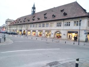 a large building with a clock tower on a street at Le Romantique in Montbéliard