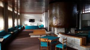a restaurant with blue chairs and tables and a fireplace at Villa Aremogna in Roccaraso