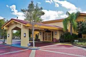 a building with a tree in front of it at La Quinta Inn Tampa Airport Stadium Westshore in Tampa