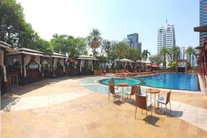 a swimming pool with chairs and tables next to a building at Sky Villas Apartments in Bangkok