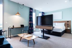 a hotel room with a television and a bed at Citadines Connect Sydney Airport in Sydney
