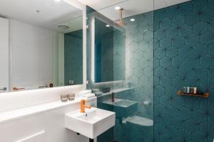 un bagno con lavandino e specchio di Citadines Connect Sydney Airport a Sydney