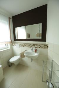 a white bathroom with a sink and a toilet at Ferienwohnung Gentner Fulda in Fulda