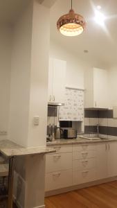 a kitchen with white cabinets and a counter top at Cockle Shell in Low Head