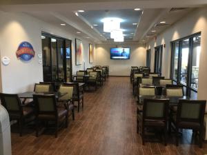 a dining room with tables and chairs and a flat screen tv at Baymont by Wyndham Page Lake Powell in Page