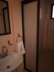 a bathroom with a sink and a shower with a towel at Hotel Plaza del Sol in Malinalco