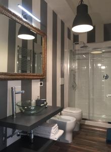 bagno con lavandino, servizi igienici e specchio di charming new loft a Bologna