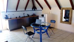 a kitchen with a table with a laptop on it at Habitation Fouyapen II in Sainte-Anne