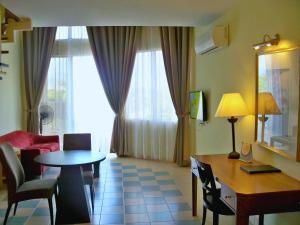 a living room with a table and a room with a couch at Lotus Desaru Beach Resort & Spa in Desaru