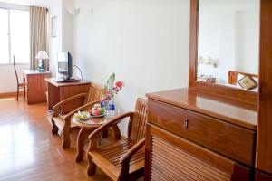 a living room with a table and a dining room at Bamboo Green Riverside Hotel in Danang