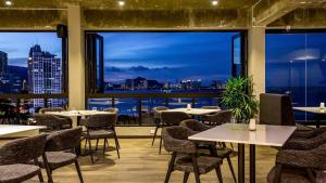 a restaurant with tables and chairs and a view of the city at Hotel Malaysia in George Town