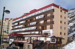 a large apartment building in front of a mountain at Sierra Nevada Rent in Sierra Nevada