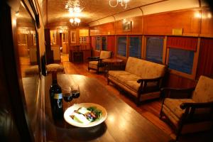 a living room with a table and a bottle of wine at Carriages Spa Retreat in Wharparilla