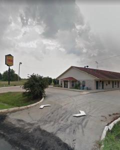 une route vide devant un bâtiment avec des flèches blanches dans l'établissement Rest Inn Motel, à Forrest City