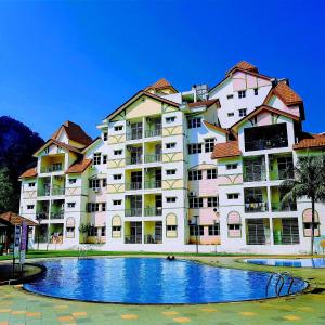 a large building with a pool in front of it at Twin Luck Home Stay in Ipoh