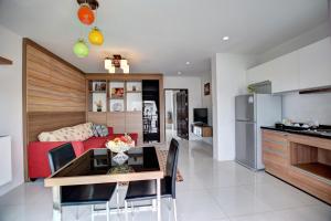 a kitchen and living room with a table and a couch at Pool Access 89 @Rawai Hotel in Rawai Beach