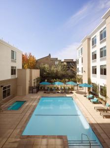 a large swimming pool with chairs and umbrellas at Hyatt Place Santa Cruz in Santa Cruz