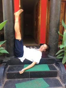 a man doing a handstand on a yoga pose at Gone Coastal Homestay in Varkala