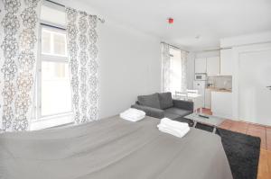 um quarto branco com uma cama e um sofá em Boende Visby em Visby