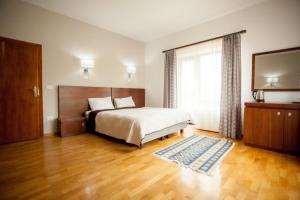 a bedroom with a bed and a large window at Matia Resort in Alba Iulia