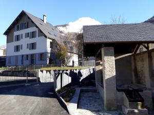 a bridge over a road with a house and a mountain at Chalet du Doumet Appartement 4 étoiles et Garage privé in Luz-Saint-Sauveur