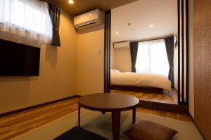 a room with a bed and a table and a window at Yukari Kyoto in Kyoto