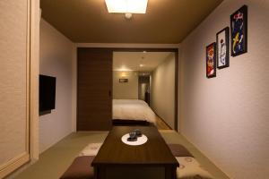 a small room with a bed and a wooden table at Yukari Kyoto in Kyoto