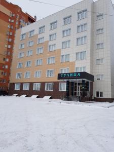 um edifício de hotel com neve em frente em Hotel Tulica em Tula
