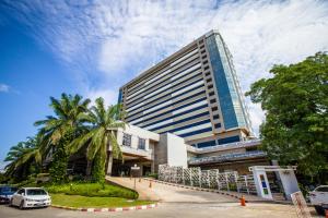 a tall building with a palm tree in front of it at The Twin Lotus Hotel in Nakhon Si Thammarat