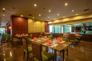 une salle à manger avec des tables et des chaises dans un restaurant dans l'établissement The Twin Lotus Hotel, à Nakhon Si Thammarat