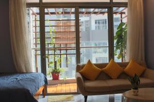 a living room with a couch and a large window at Cherry Homeapart Vinhomes Central Park in Ho Chi Minh City