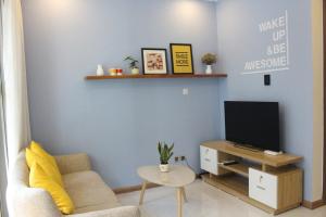 a living room with a couch and a tv at Cherry Homeapart Vinhomes Central Park in Ho Chi Minh City