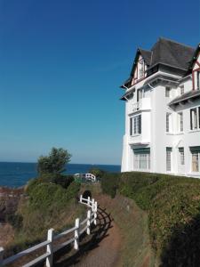 a white house on a hill next to the ocean at Villa de villégiature à Saint-Quay-Portrieux in Saint-Quay-Portrieux +26 photos