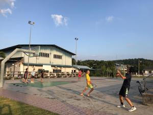 a group of people playing a game of basketball at SingSport Holiday House in Mersing