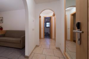 a living room with a couch and a hallway at Appartamenti Villa Olympia in Corvara in Badia