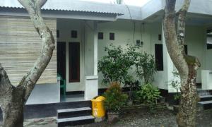 Pedek Homestay في برايا: منزل أمامه سلة مهملات صفراء