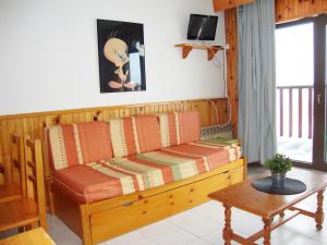 a bedroom with a bed with orange pillows and a table at Apartamentos Paradis Blanc 3000 in Pas de la Casa