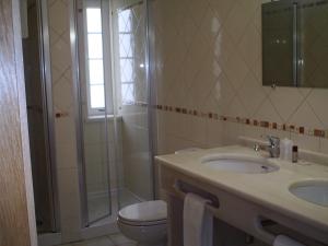 a bathroom with a shower and a sink and a toilet at Hotel Serafim in Almodôvar