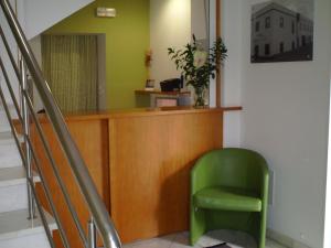 uma cadeira verde sentada numa sala de espera em Hotel Serafim em Almodôvar