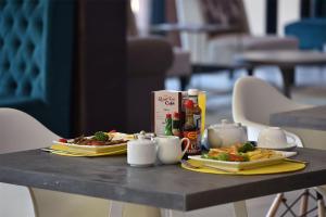 una mesa con dos platos de comida. en Regal Inn Umhlanga Gateway en Durban