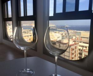 サンタクルス・デ・テネリフェにあるVacacional panorámica al mar centro Santa Cruzの窓際に座るワイングラス2杯